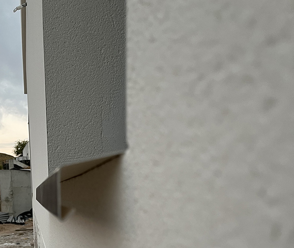 Instalación de vierte agus de aluminio sobre ventana.